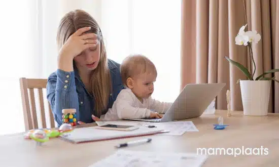 Moeder die werkt met baby op schoot