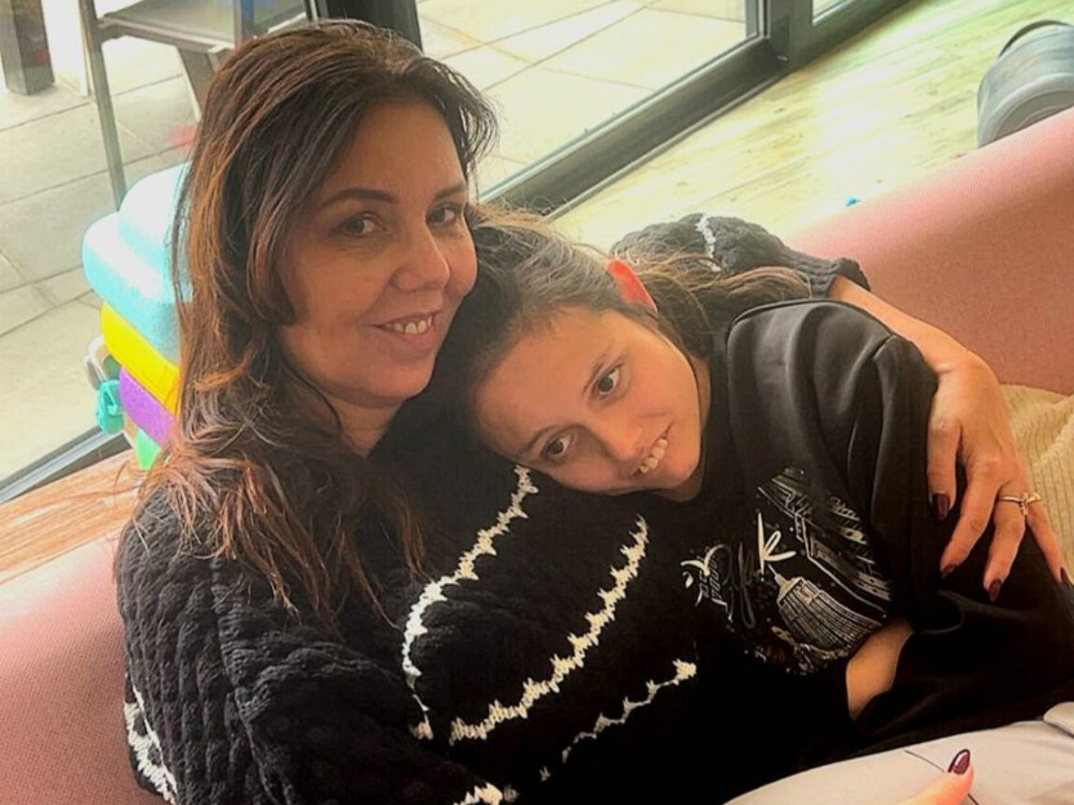 kind met autisme moeder en dochter knuffelend op de bank