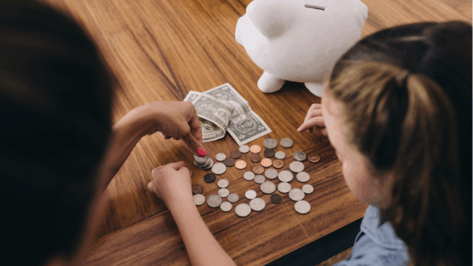 kosten gezin met puber en kind foto van moeder met dochter die voor spaarpot zit