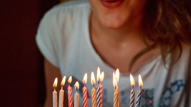 anonieme verjaardagskaart foto van meisje die kaarsen uitblaast